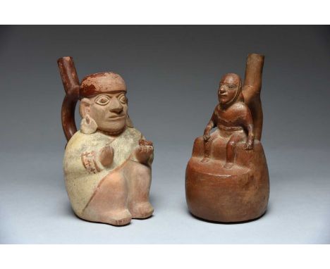 Two Moche stirrup spout vesselsPeru, circa 100 - 500 ADterracotta, one modelled as a seated figure holding a bowl, 22cm high 