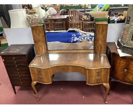 1950s Walnut Dressing Table with a Central Mirror, flanking bow-fronted cupboards, shaped base, central drawer, four small dr