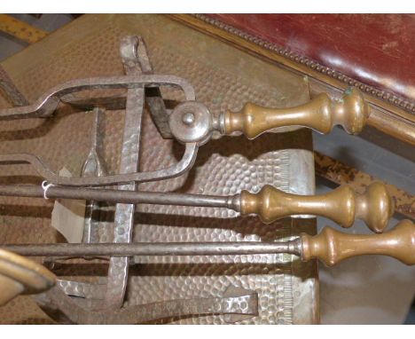 A PAIR OF WROUGHT IRON AND COPPER ARTS AND CRAFTS FIRE DOGS AND A SET OF THREE FIRE TOOLS