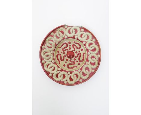 A William De Morgan Farini plate, moulded in low relief with inter-linking circle border, the well with similar raised decora
