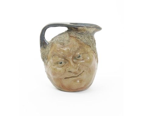 A Martin Brothers stoneware face jug, modelled in relief with a smiling face, the reverse a similar smiling face, glazed grey