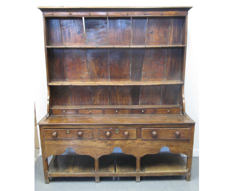 19TH CENTURY WELSH OAK RACK BACKED, POT BOARD DRESSER, the boarded back with moulded cornice with partly original iron hooks,