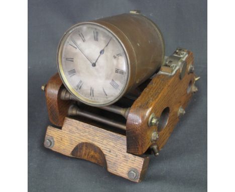 BRASS DESK CLOCK in the form of a trench mortar with silvered Roman face, on a brass mounted, oak carriage.  Face 8cm diamete