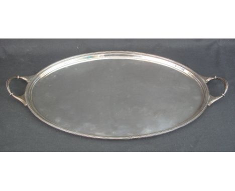EARLY 20TH CENTURY LARGE SILVER TWO HANDLED SERVING TRAY of oval and plain form with raised, stepped edge, Sheffield 1929, ma