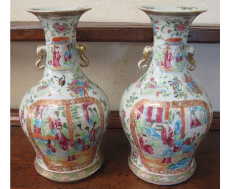 PAIR OF CHINESE PORCELAIN CANTON BALUSTER SHAPED VASES, overall decorated in Famille Rose pallet with reserved panels of cour