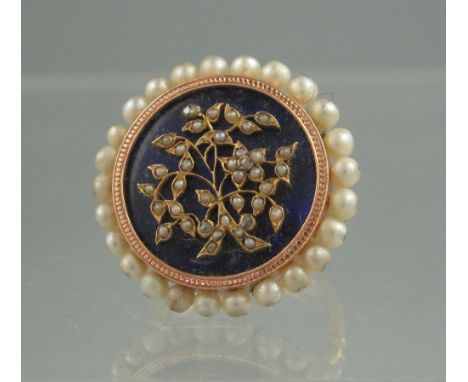 VICTORIAN BLUE ENAMEL AND PEARL RING. The circular blue enamel ground featuring a gold work spray of flowers set with seed pe