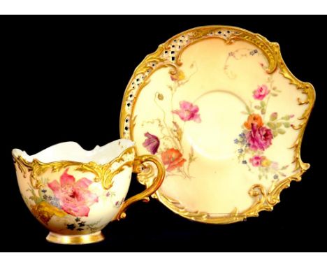 A ROYAL WORCESTER RETICULATED ROCOCO REVIVAL CUP AND SAUCER DECORATED WITH WILD FLOWERS, PROBABLY AFTER DESIGNS BY EDWARD RAB