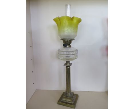 An oil lamp with clear glass reservoir and yellow etched glass shade, 77cm tall, in generally good condition 