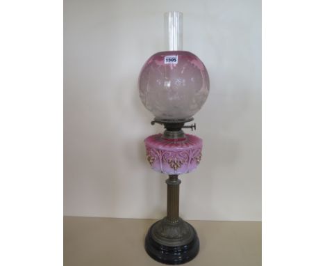 An oil lamp with an etched shade and pink glass font, 67cm tall, generally good, small chips to shade, wear to gilt 