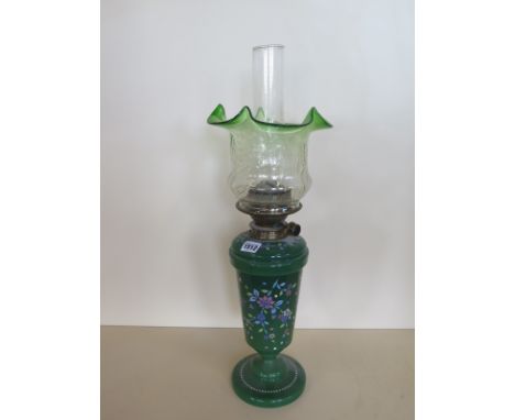 An oil lamp with enamel green glass body and green tinted shade, 60cm tall, good condition, minor chips to base rim of shade 