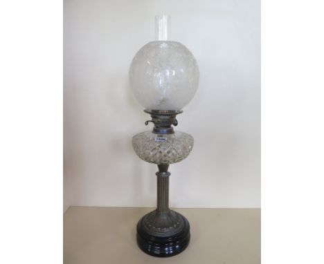 An oil lamp with an etched shade and cut clear glass font, 66cm tall, in good condition 