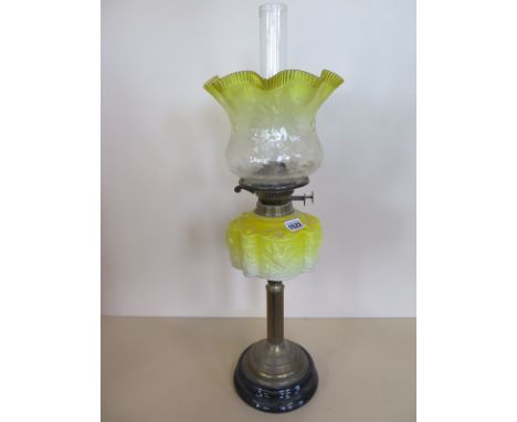 An oil lamp with yellow moulded glass font and yellow tinted shade, 65cm tall, overall good condition 