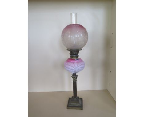 An oil lamp with etched cranberry tinted globe shade and pink glass moulded font - 71cm tall, generally good condition, 