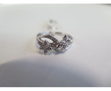 A hallmarked 9ct white gold diamond floral crossover ring, size N, approx 3.4 grams, new condition, ex jewellers stock 