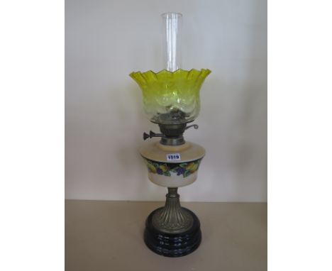 An oil lamp with a transfer decorated font and yellow tinted etched shade, generally good, minor chips to base of shade, mino