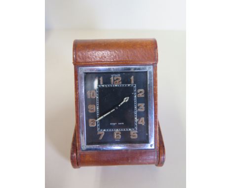 An eight day Le Coultre leather covered travel clock with a 5cm x 4.5cm dial case in reasonably good condition. Hands advance