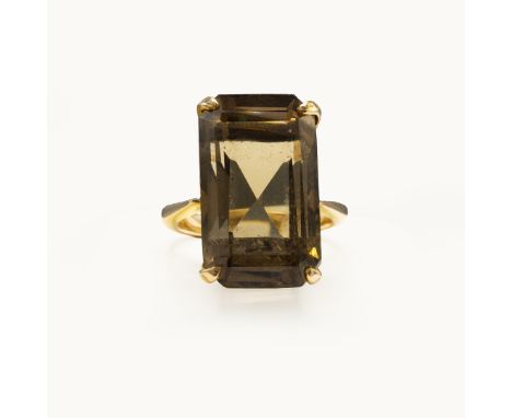 A 14CT GOLD SMOKY QUARTZ DRESS RING. the large emerald cut stone in a claw set mount, ring size M, 8 grams, complete with box