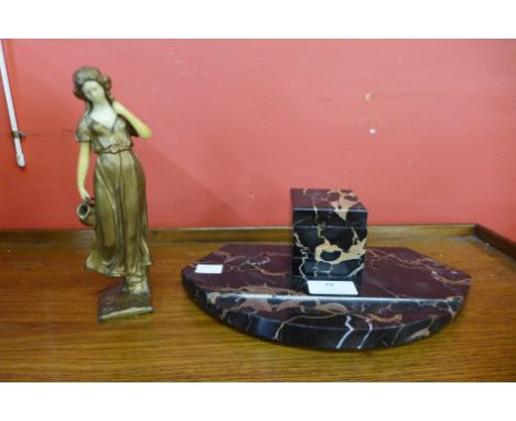 An Art Deco marble inkwell and a faux ivory and gilt metal figure of a water carrier 