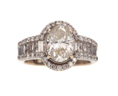 DIAMOND DRESS RING, the oval stone of approximately 1.58 carats, flanked by round and baguette cut diamonds, within a round b