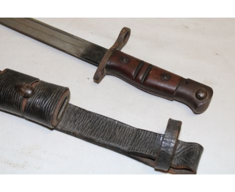 A First War United States Remington bayonet with single edged blade dated 1917 in steel mounted leather scabbard with leather