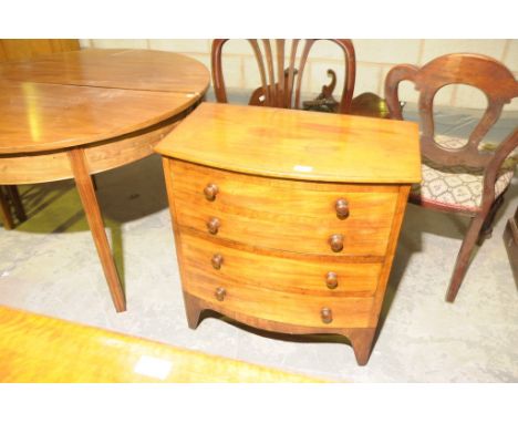 A 19th Century mahogany bow front commode chest with a hinged top and 4 faux drawers with turned handles.