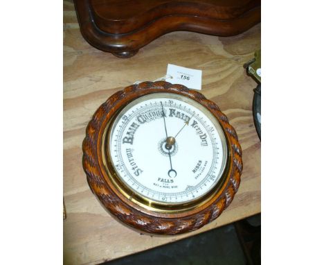 An Early 20th century oak cased barometer with a rope border and white enamel dial.