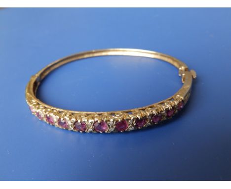 A ruby & diamond set 9ct gold bangle.