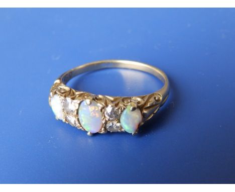 A three stone opal ring set with small diamonds.