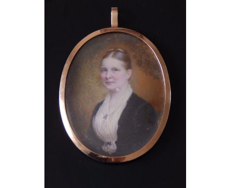 An early 20thC oval watercolour miniature portrait of a woman, 3.6” high – some loss to paint around face – in metal pendant 