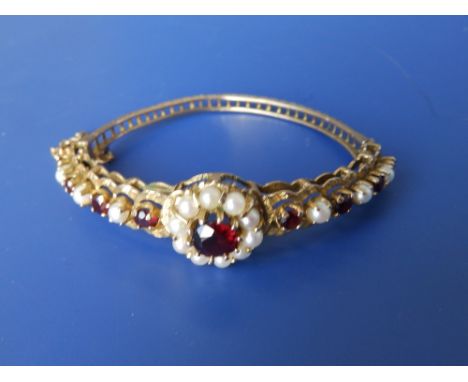 A pearl and imitation garnet set 9ct gold bangle.