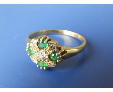 An emerald & diamond dress ring.