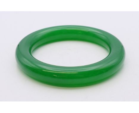 An apple green jade bangle. 6 cm internal diameter. 