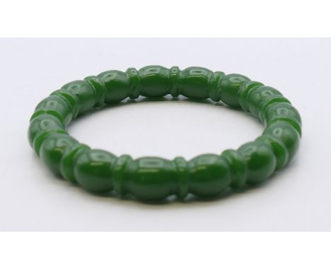 A shaped jade bangle.  5.75 cm internal diameter. 