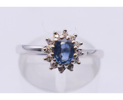 A 9 ct white gold sapphire and diamond cluster ring. Ring size M/N. 2.9 grammes total weight.