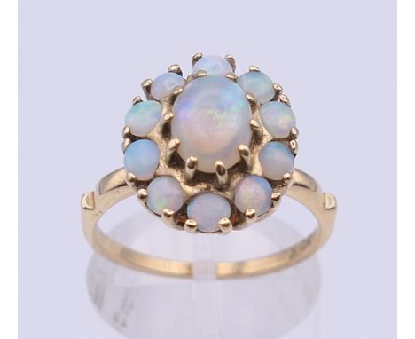 A 10 ct gold opal cluster ring. Ring size M/N. 3.6 grammes total weight.