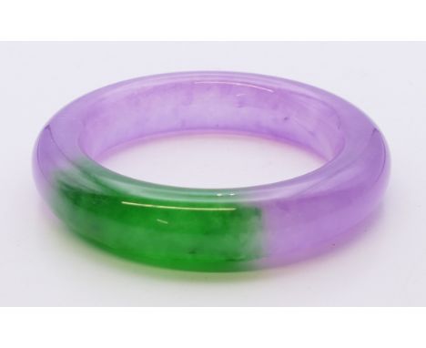 A two-tone jade bangle.  5.75 cm internal diameter.