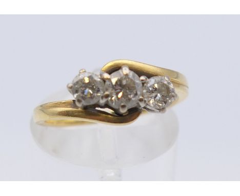 An 18 ct gold three stone diamond ring. Ring size L/M. 3.7 grammes total weight.