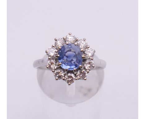 An unmarked 18 ct white gold sapphire and diamond circular cluster ring. Ring size O. 5.7 grammes total weight. 