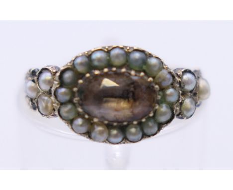 An antique unmarked gold seed pearl and gemstone ring. Ring size I/J. 1.7 grammes total weight.