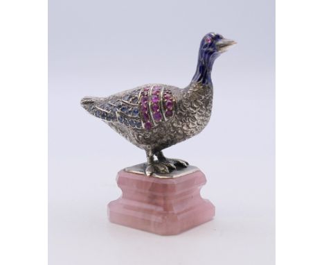 An unmarked silver and enamel gem set model of a goose mounted on a rose quartz stepped plinth base. 7 cm high. 