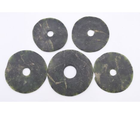 Five Chinese dark green jade bi discs of various sizes, Neolithic Period. The largest 7.5 cm diameter.Provenance: The Larkin/