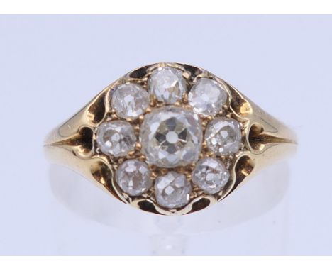 An unmarked gold and diamond cluster ring. Ring size O/P. 3.2 grammes total weight.