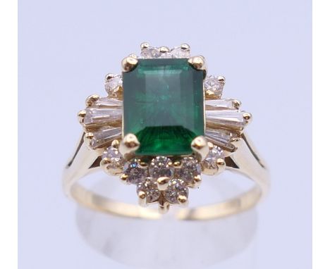 An unmarked gold emerald cluster ring. Ring size S/T. 6.2 grammes total weight.