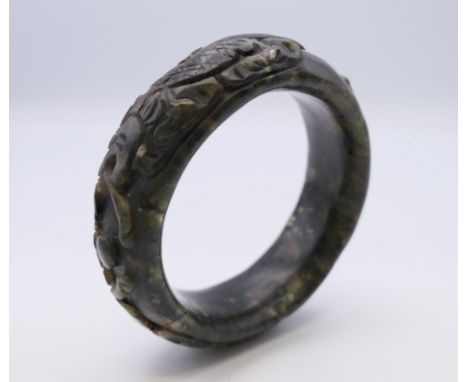 A Chinese jade bangle with carved dragon, Qing Dynasty. 6 cm diameter.Provenance: The Larkin/Minney Collection. 
