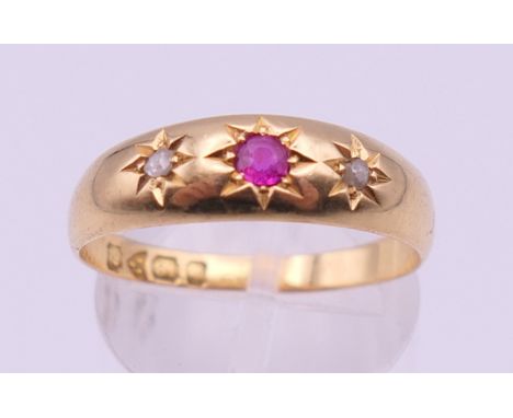 An 18 ct gold diamond and ruby gypsy set ring. Ring size Q/R. 3.6 grammes total weight.