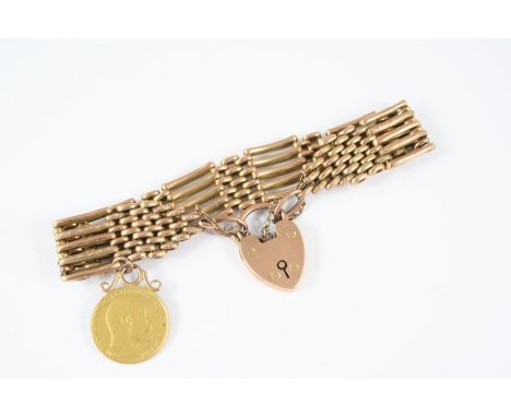 A 9CT. GOLD FANCY GATE LINK BRACELET formed with foliate engraved and plain links, with padlock clasp, and suspending a mount