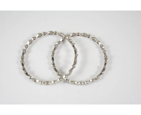 A PAIR OF DIAMOND SET BANGLES each openwork bangle is mounted with quatrefoils of circular-cut diamonds, each divided by a si