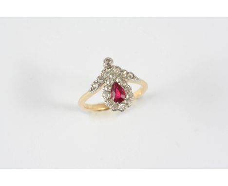 A SYNTHETIC RUBY AND DIAMOND CLUSTER RING the pear-shaped synthetic ruby is set within a surround of circular-cut diamonds, i