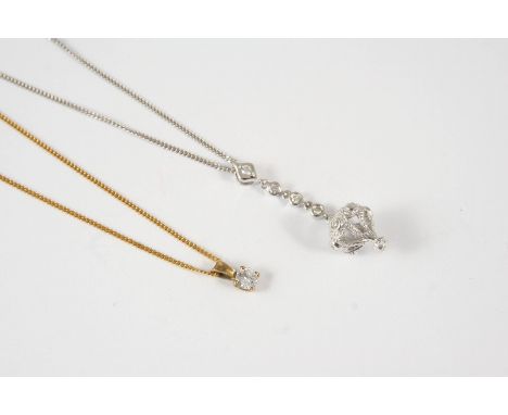 A DIAMOND SOLITAIRE PENDANT the circular brilliant-cut diamond is set in 9ct. yellow gold, on a 9ct. yellow gold fine link ch