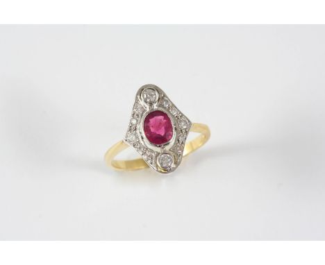 A RUBY AND DIAMOND CLUSTER RING the oval-shaped ruby is set within a surround of two circular-cut diamonds and smaller circul